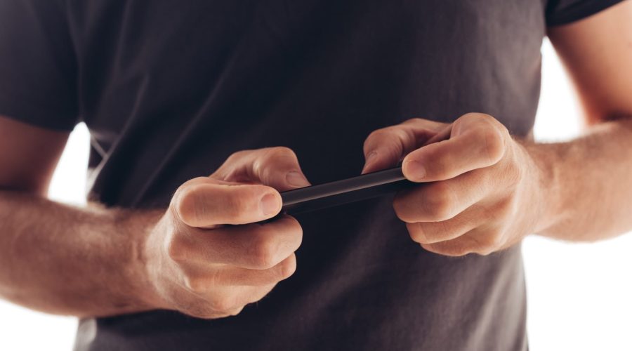 Man playing mobile video game on smartphone Man playing mobile video game on smartphone